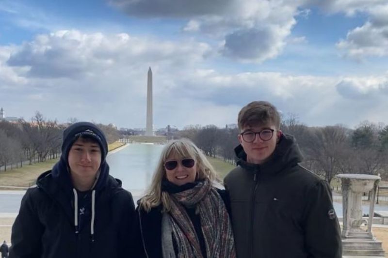 three student standing smiling  to camera outdoors